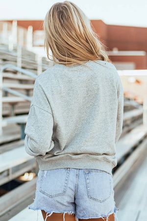 Gray sweatshirt with baseball stitch bow graphic detail on back.
