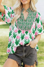 Playful floral v-neck blouse with puff sleeves and green patterned yoke