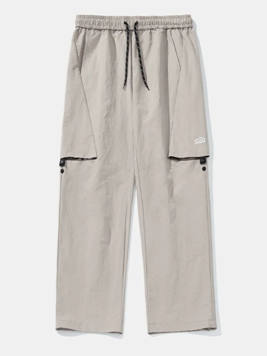Gray cargo pants with drawstring waist and black trim pockets.