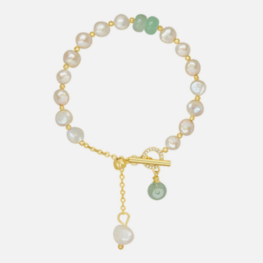 Pearl and green stone toggle bracelet with gold chain and pearl drop.