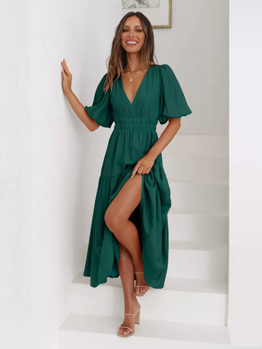 Dark green midi dress with puff sleeves, V-neck, cinched waist, tiered skirt, and thigh-high slit.