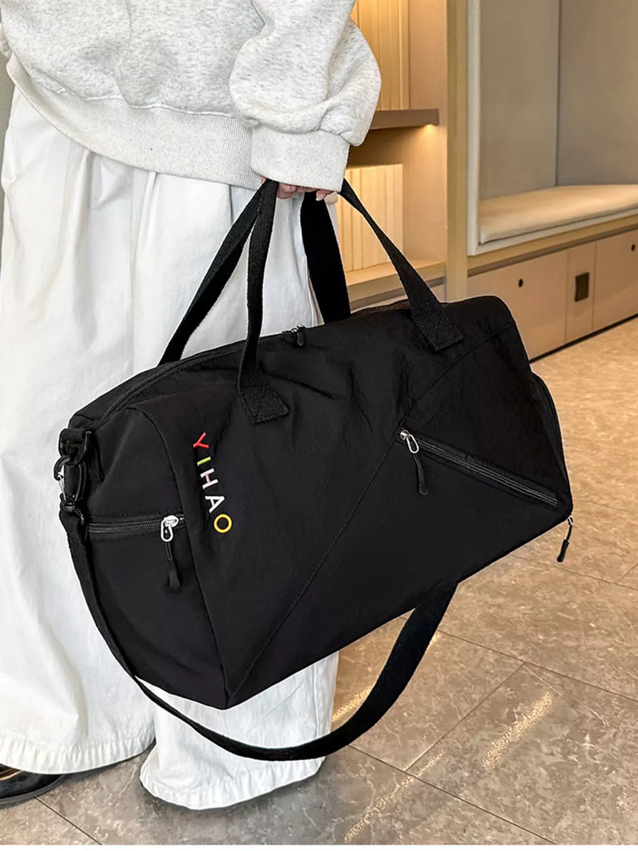 Black duffel bag with colorful embroidered logo and zippered pockets