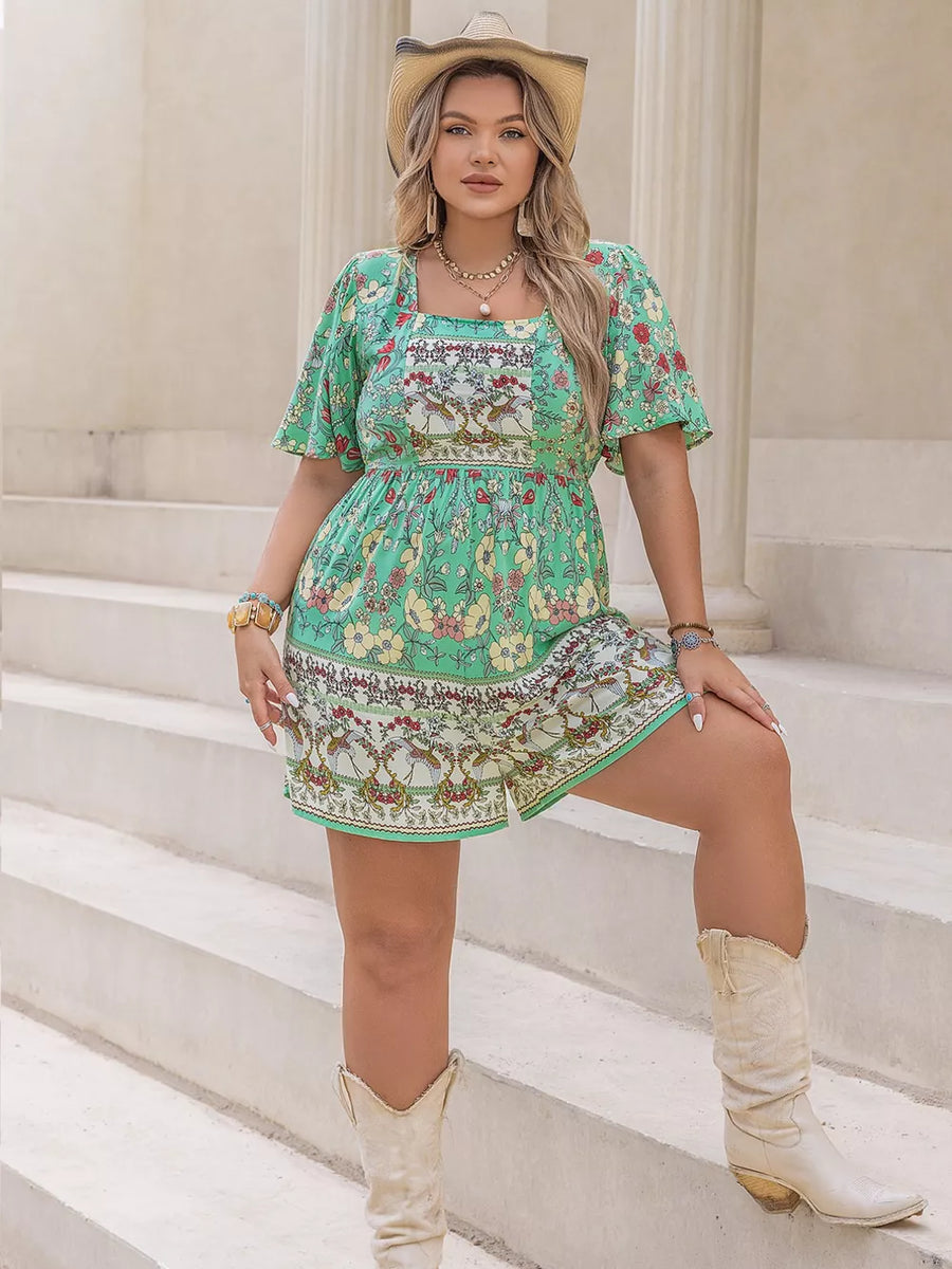 Plus-size green floral romper with square neck, cinched waist, and short sleeves.