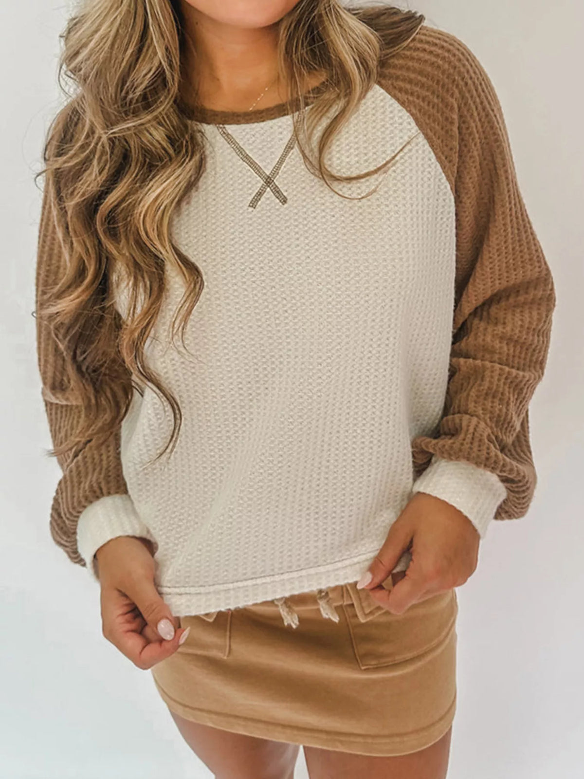 Beige waffle knit raglan sleeve top with contrast sleeves and X detail at neckline.