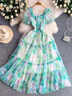 Floral tiered midi dress in light green with smocked bodice and puff sleeves.
