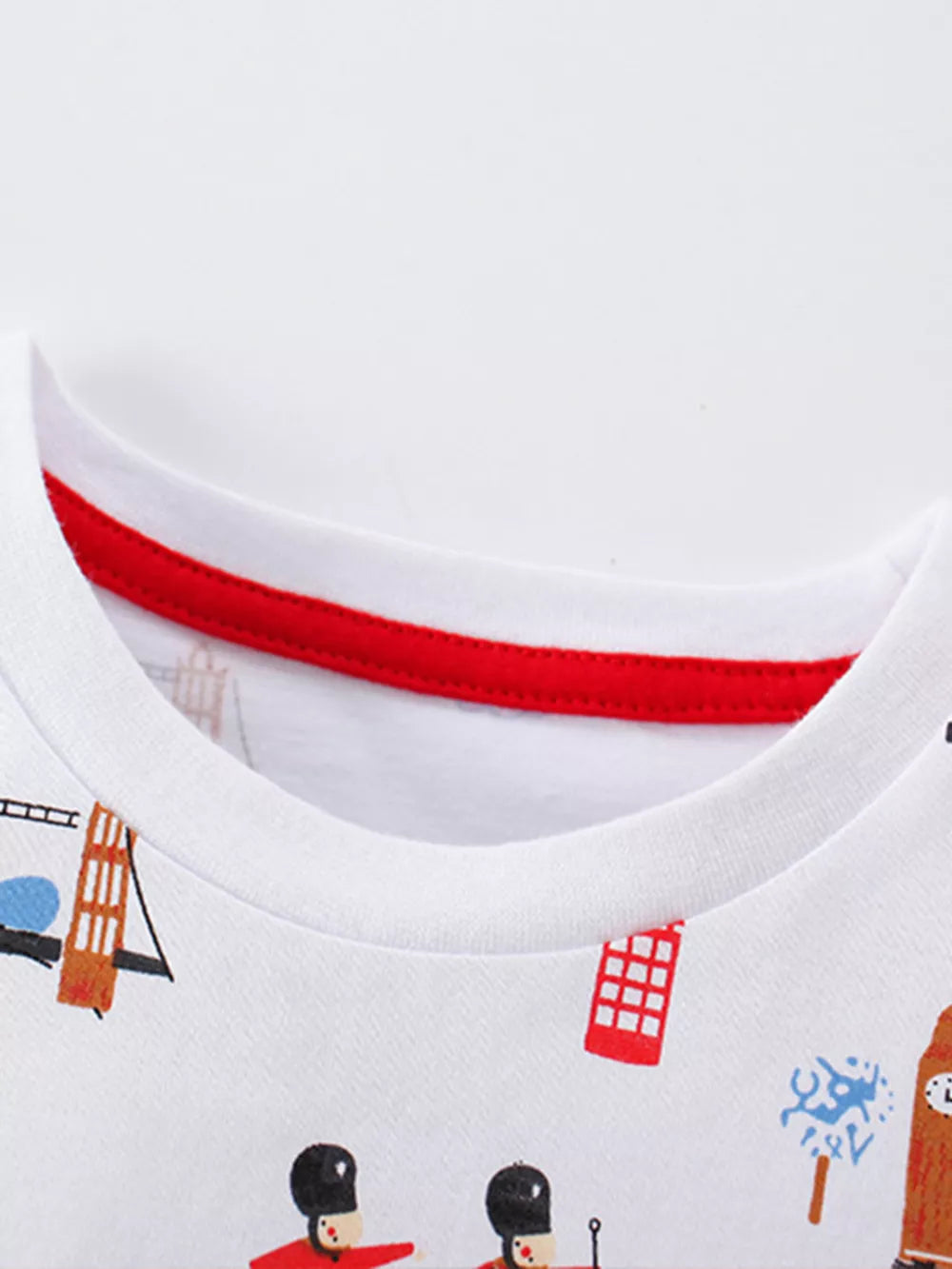 White toddler t-shirt with London-themed print and red trim neckline.