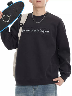 Black oversized crew-neck sweatshirt with embossed text detail.