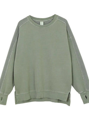 Sage oversized sweatshirt with raw-edge seams and thumbholes.