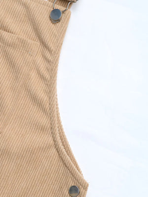 Tan corduroy overall dress detail with pocket and strap hardware