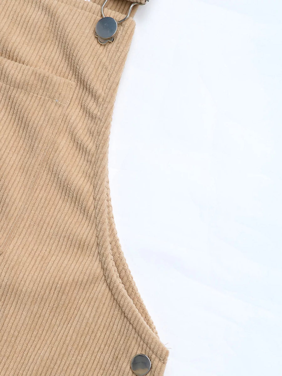 Tan corduroy overall dress detail with pocket and strap hardware
