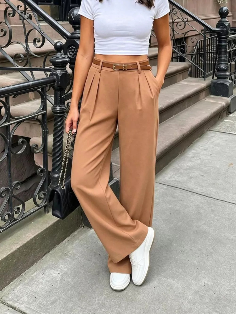 Brown pleated wide-leg pants with a belted waist and pockets, styled with a white crop top.