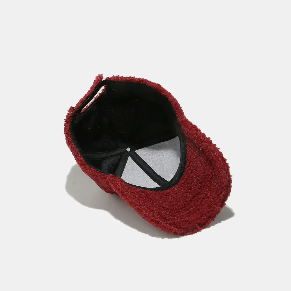 Burgundy textured sherpa baseball cap with black lining and adjustable strap.