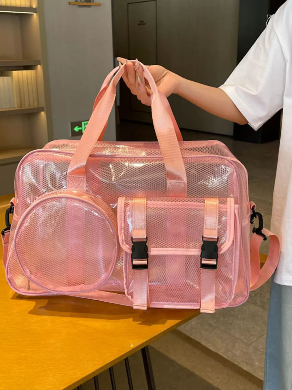 Pink PVC travel organizer bag with multiple pockets and buckle closures.