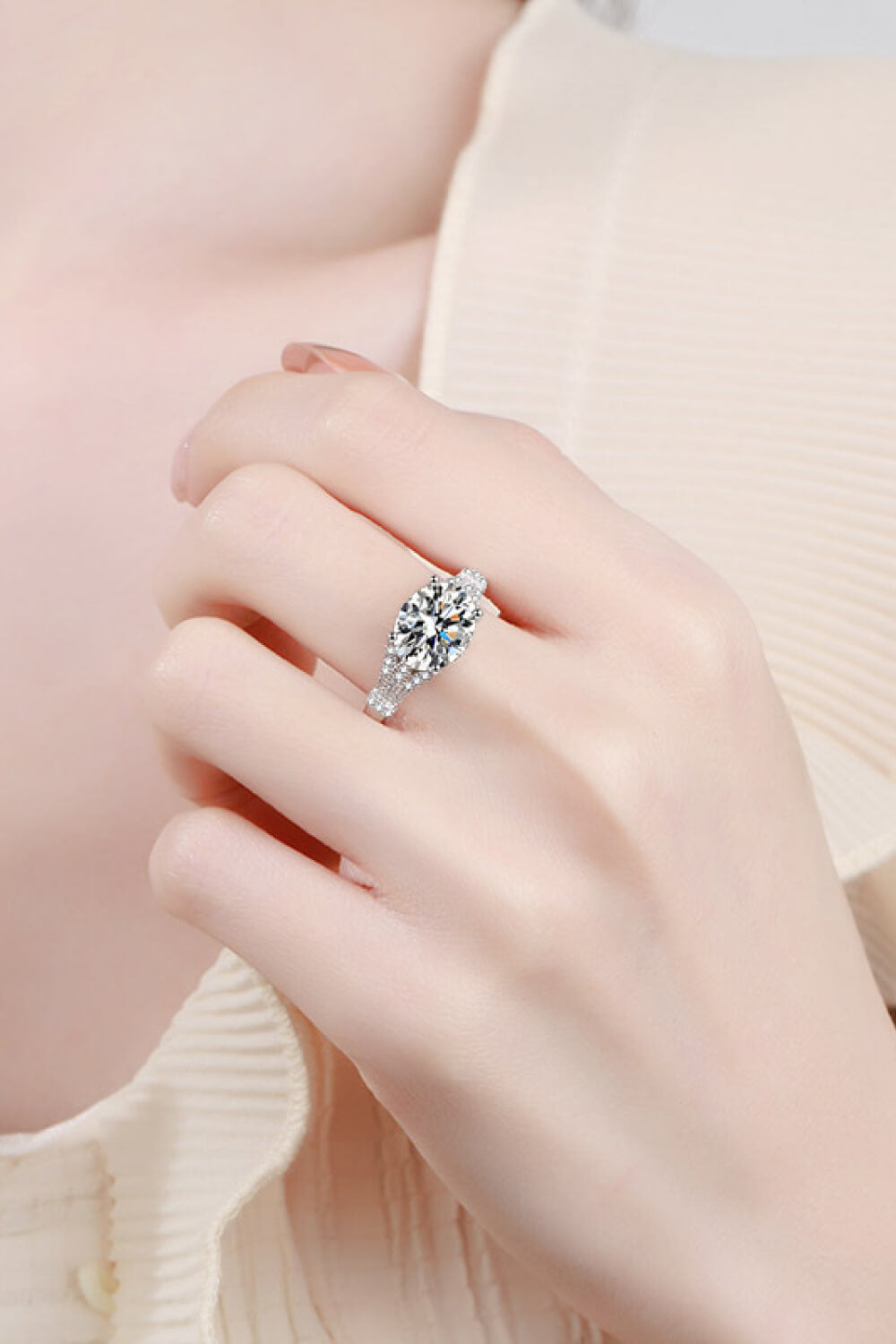 Silver pavé-set moissanite solitaire ring with a split band.