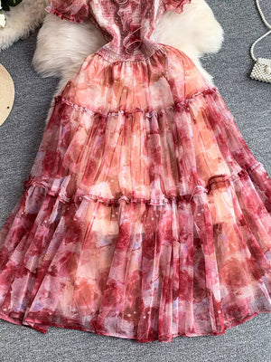 Floral tiered midi dress in pink with smocked bodice and ruffled hem.