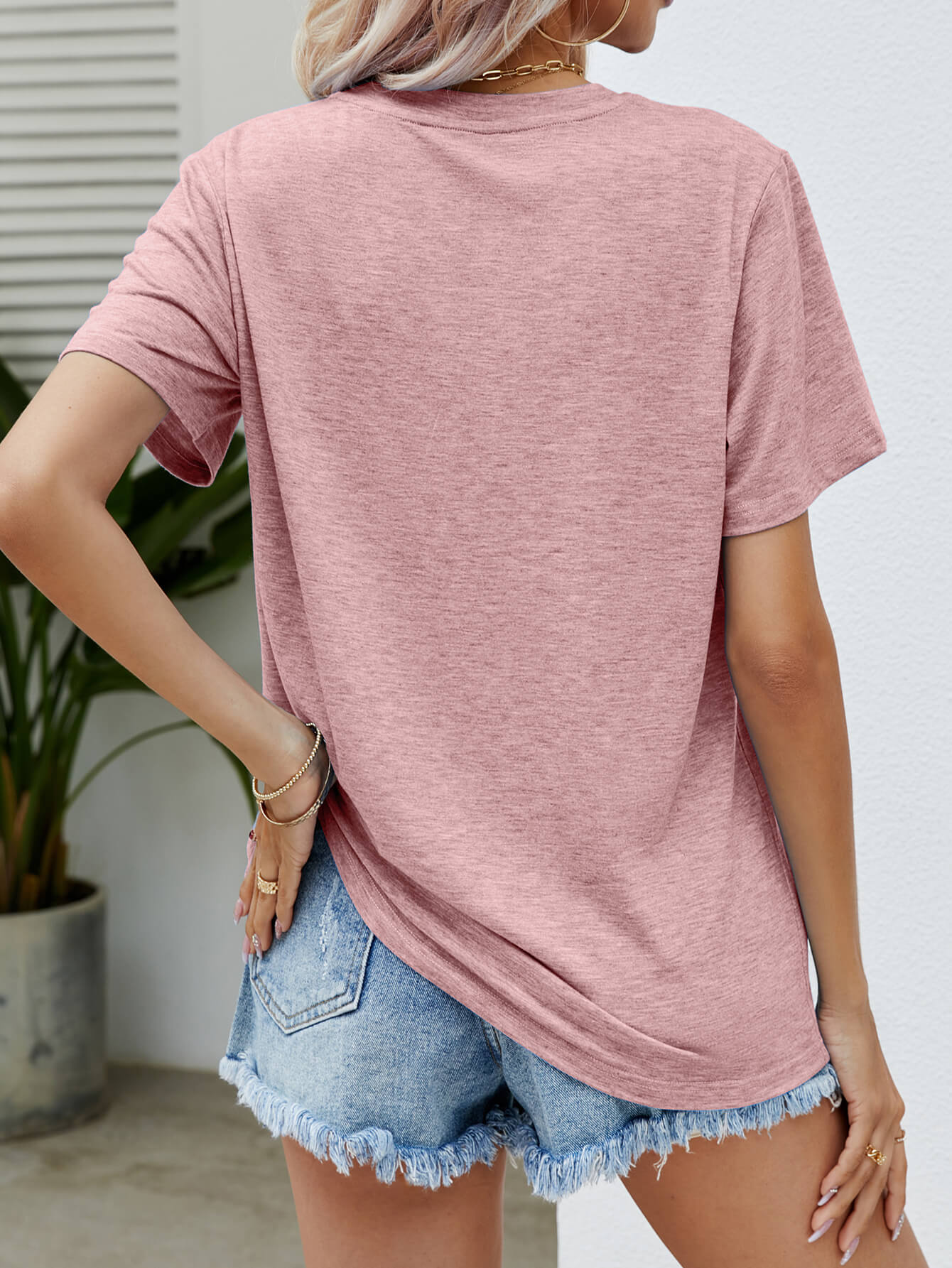 Dusty Pink heathered t-shirt with short sleeves and a relaxed fit, paired with denim shorts.