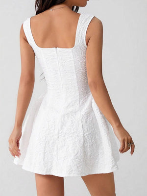 Textured white a-line mini dress with square neckline and fitted bodice.