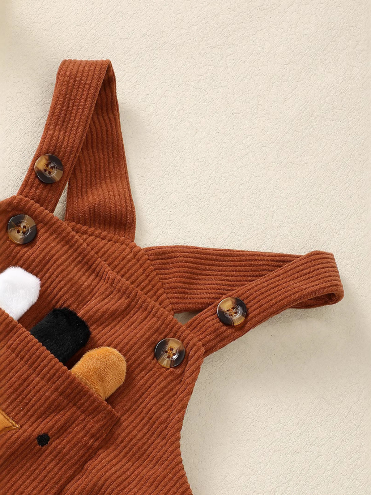 Brown corduroy overalls with animal applique and button details.