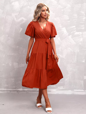 Orange-red tiered midi dress with flutter sleeves and belted waist