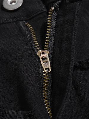 Black denim jeans with frayed edges and a brass zipper detail.