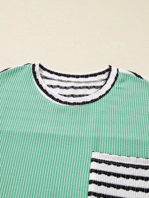 Turquoise twisted ribbed long-sleeve top with striped neckline and pocket detail.