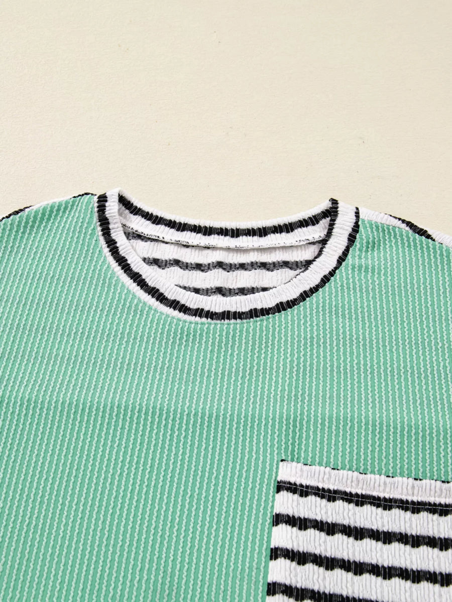 Turquoise twisted ribbed long-sleeve top with striped neckline and pocket detail.