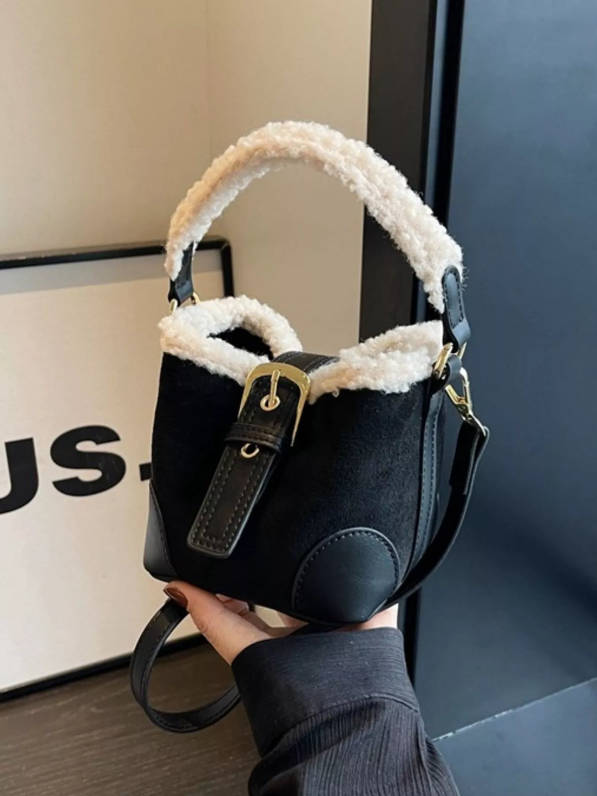 Black fuzzy trim crossbody bucket bag with gold buckle detail