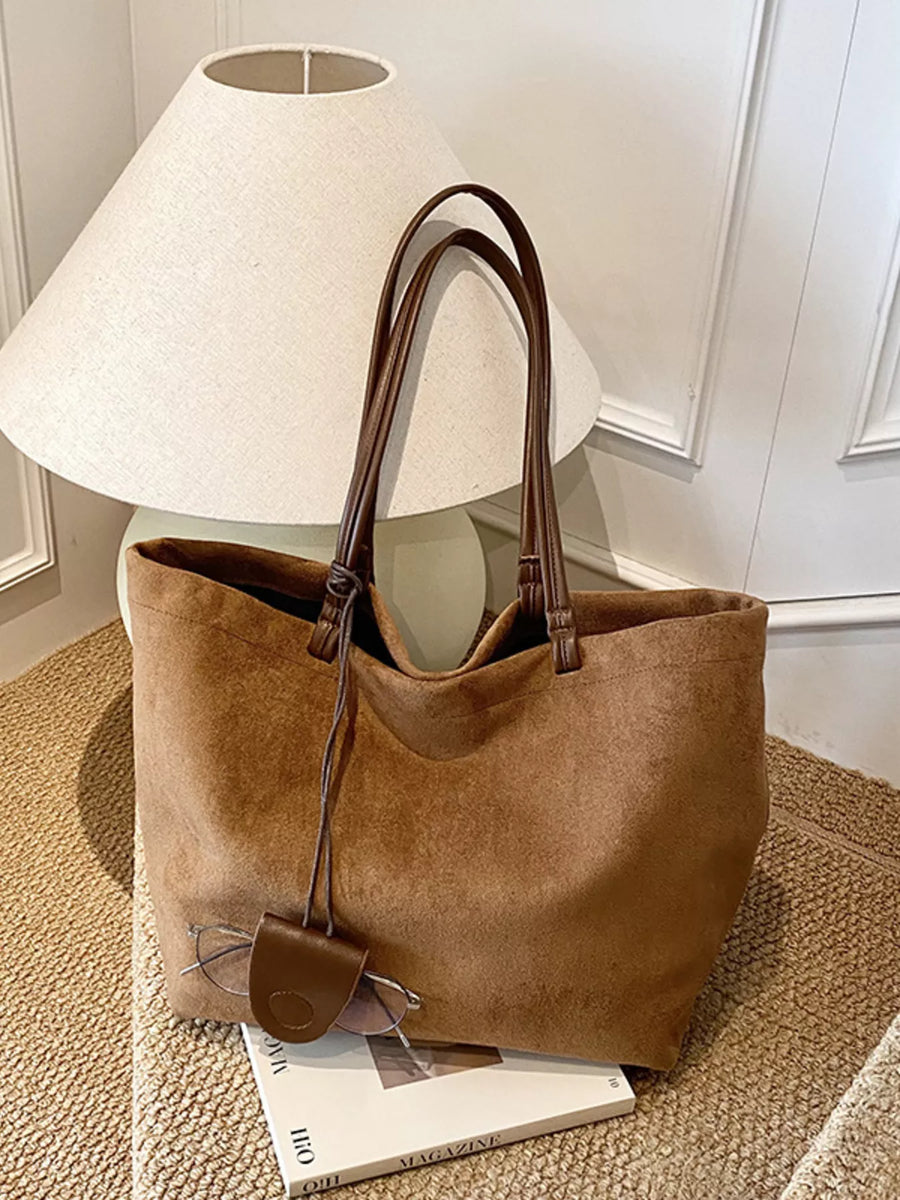 Large caramel brown suede tote bag with leather handles and a glasses holder detail.