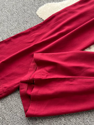 Wine red wide-leg jumpsuit detail showing hem and stitching.