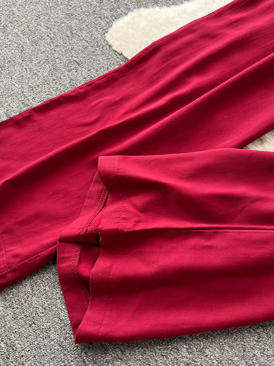 Wine red wide-leg jumpsuit detail showing hem and stitching.