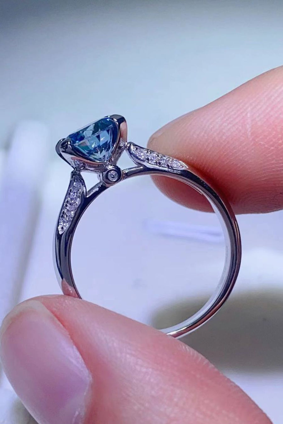 Celestial blue moissanite engagement ring with diamond accents on a silver band.