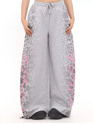 Men's grey cotton sweatpants with leopard print and pink graphic detail, wide leg, drawstring waist.