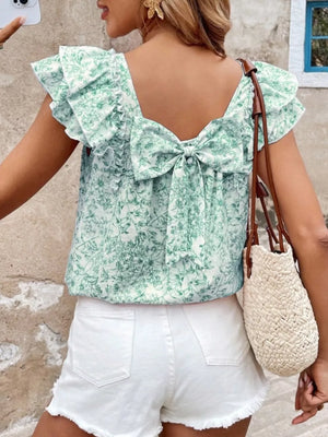 Green floral ruffle blouse with back bow detail and short sleeves.