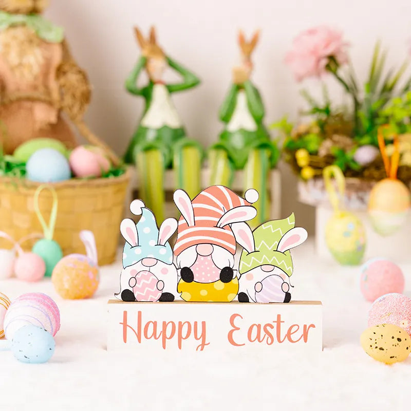 Easter wooden gnome trio display with bunny ears and patterned hats, on a Happy Easter sign.