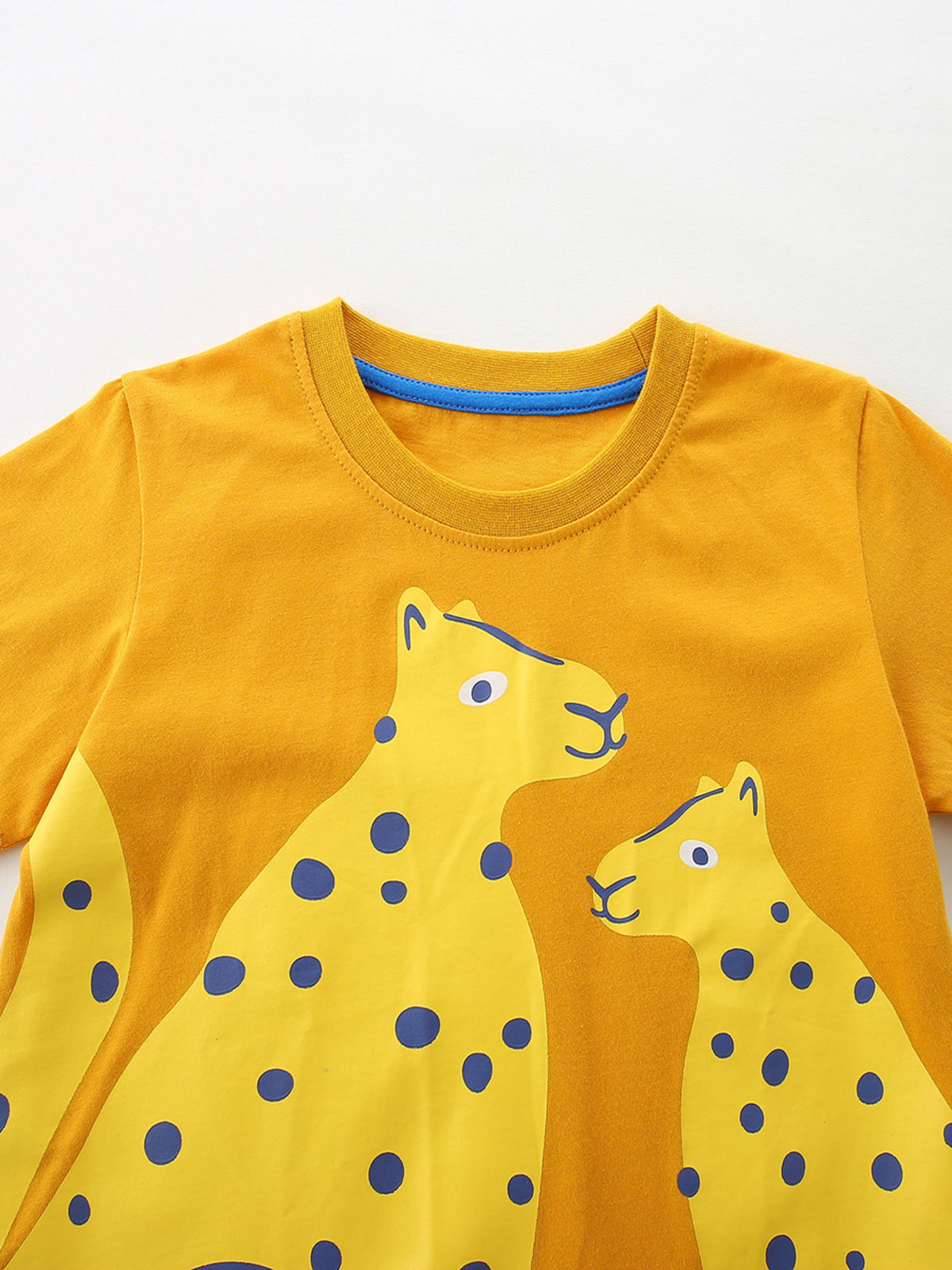 Yellow cotton crew neck t-shirt with playful yellow cheetah print and blue polka dots.