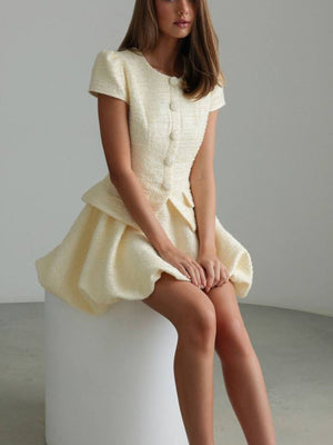 Cream textured button-down dress with short sleeves and bubble hem skirt.