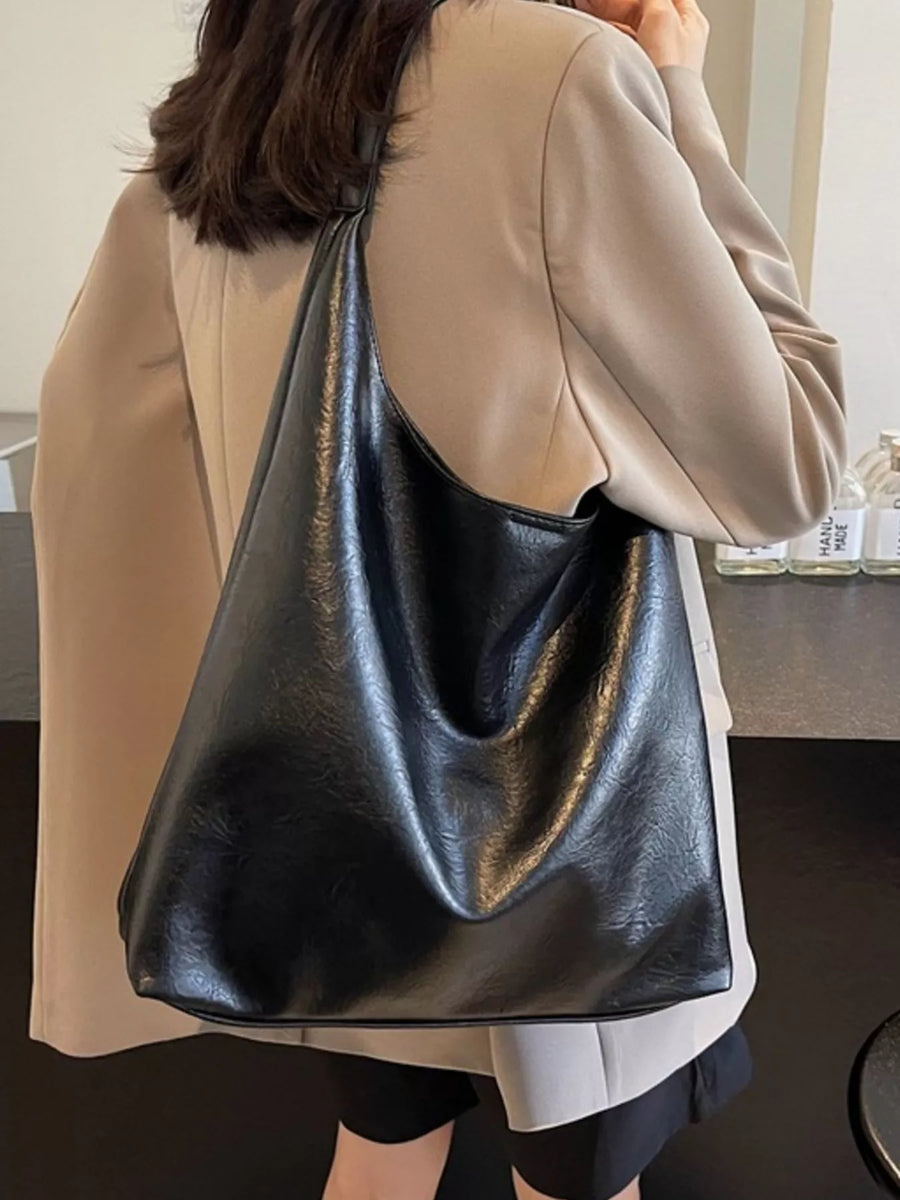 Black PU leather tote bag with a slouchy, sculptural shape and single strap.