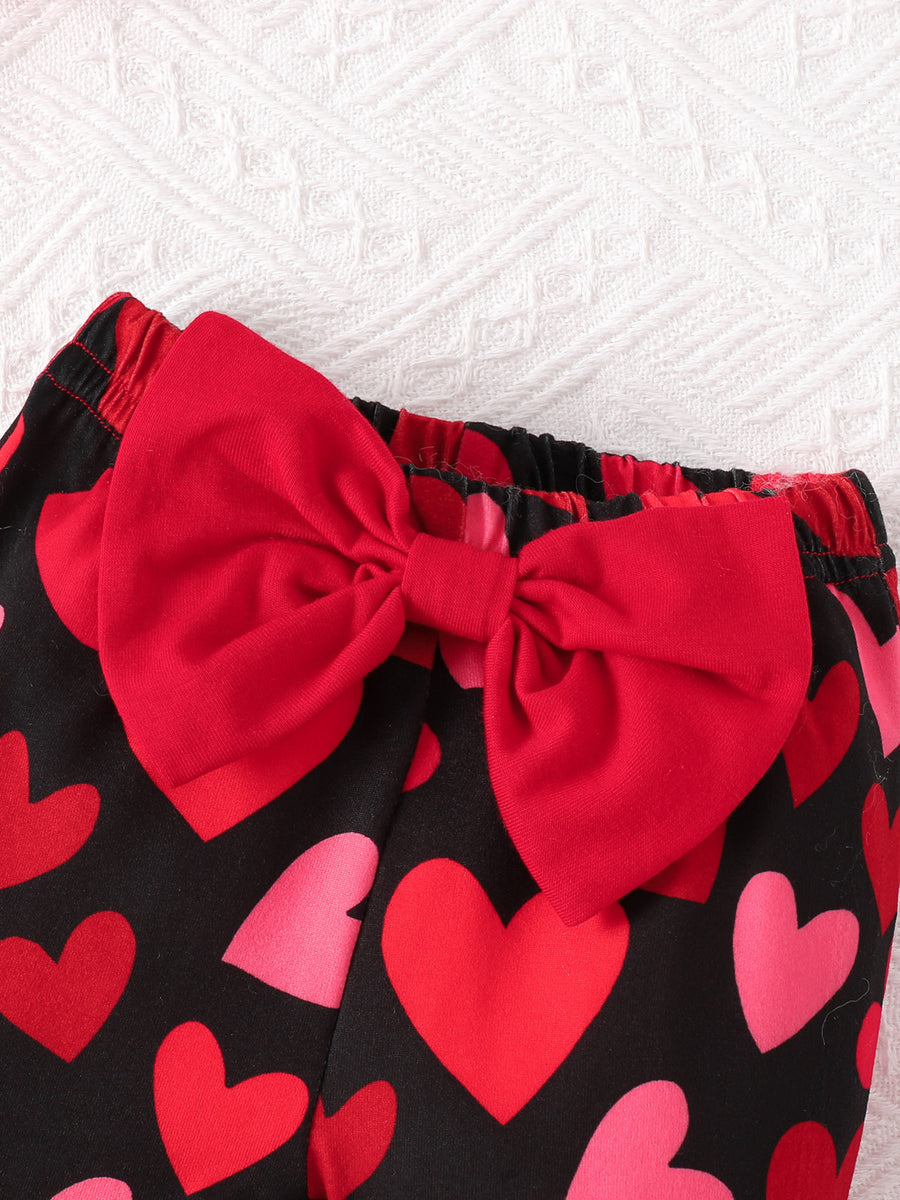 Baby bell-bottoms with black heart print and red bow detail.