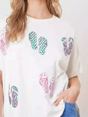 White polyester t-shirt with a scattered flip-flop print in pink and green.