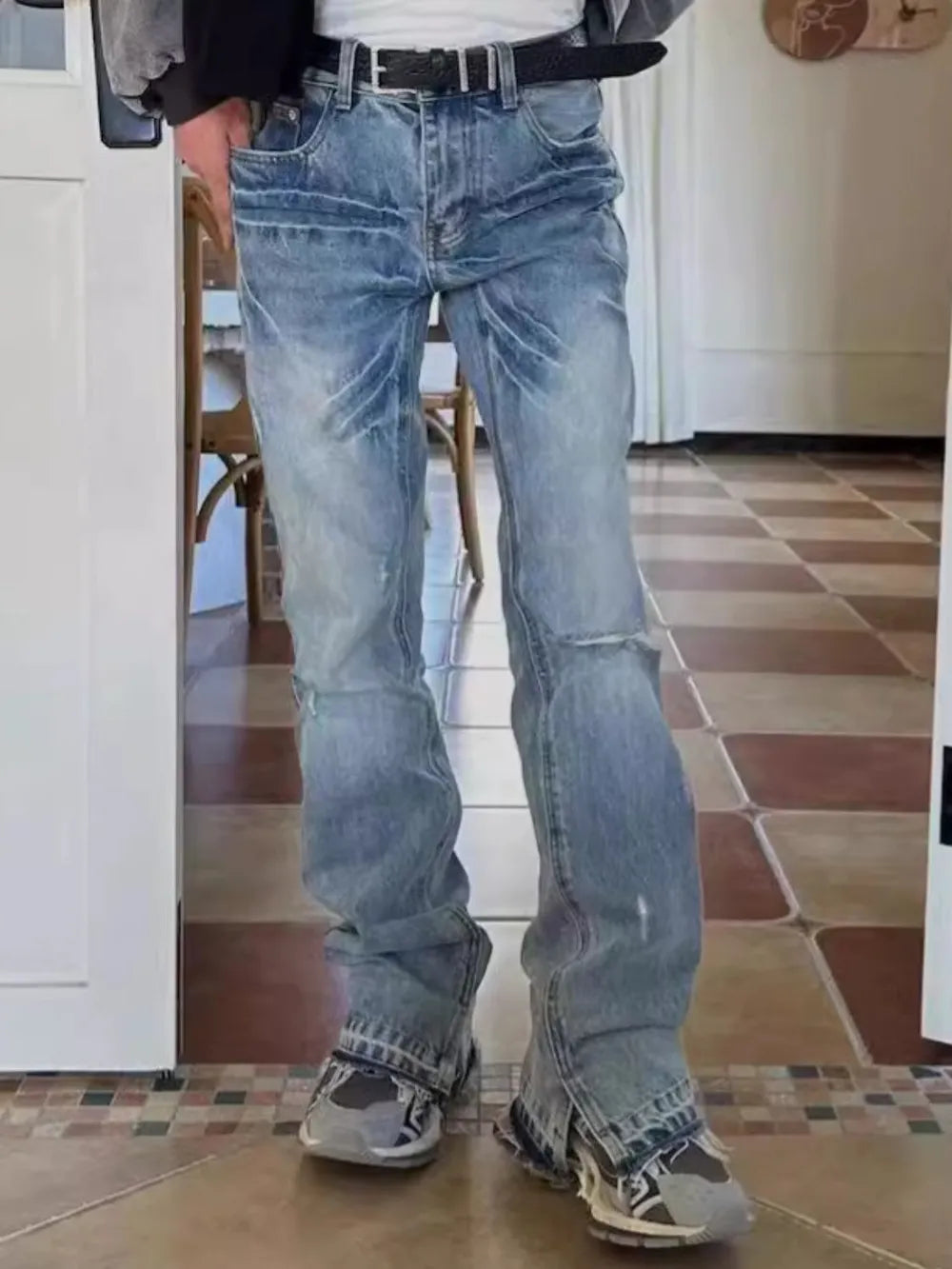 Medium wash denim jeans with distressed details and split hems