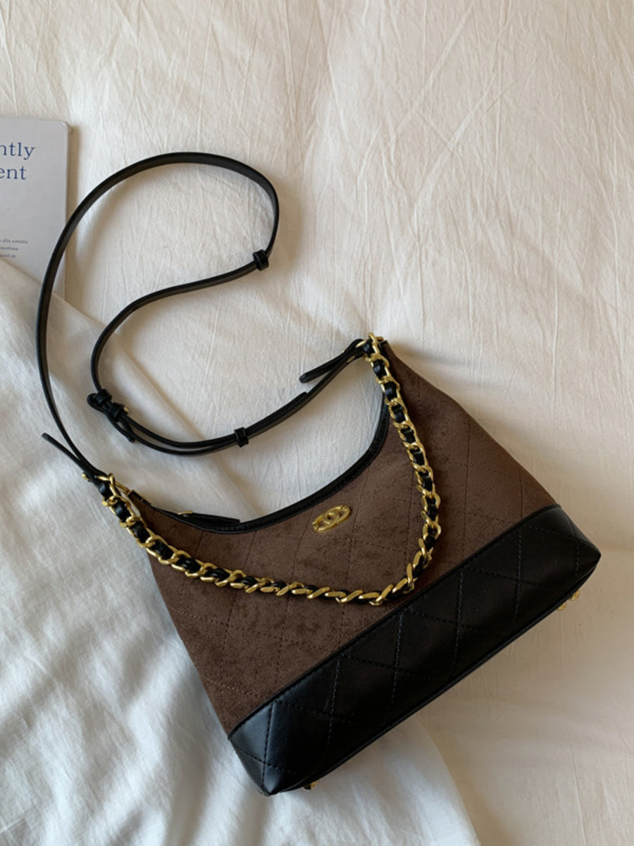 Brown half-moon crossbody bag with chain detail and quilted black trim