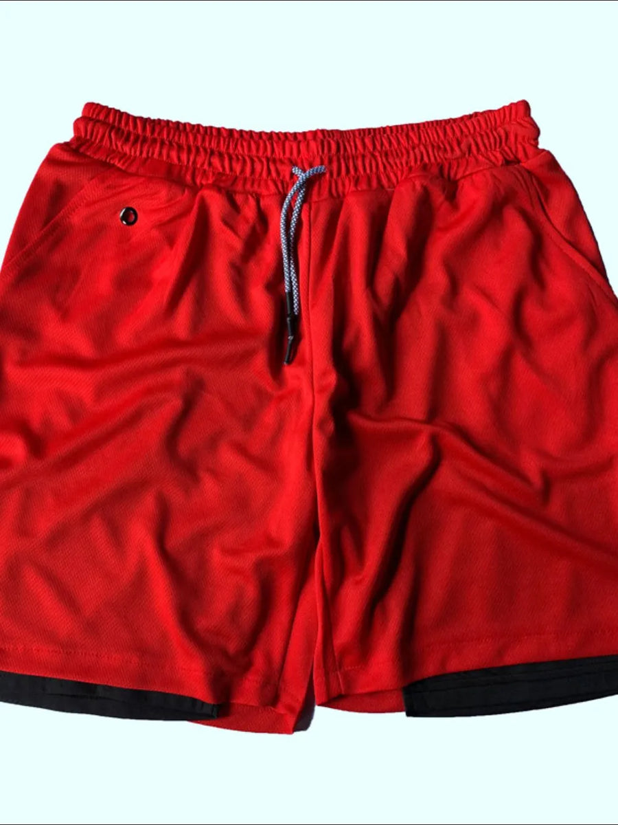 Red dual-layered performance shorts with black trim and drawstring.