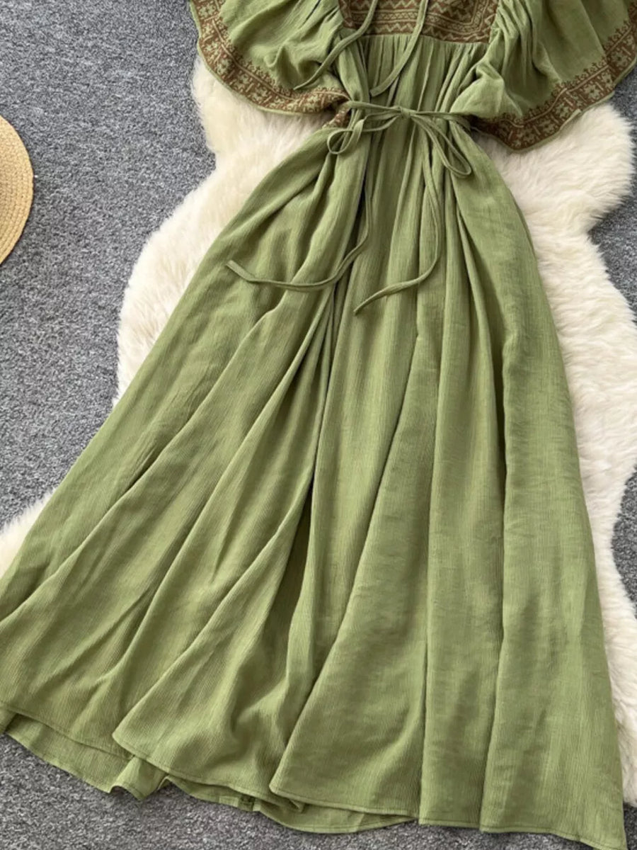 Mint green embroidered V-neck maxi dress with tie waist and flowing skirt.