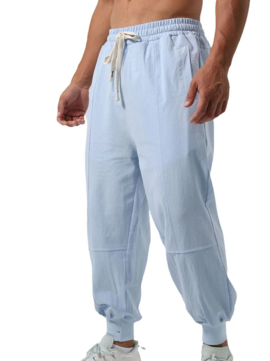Light blue relaxed fit joggers with seam details and adjustable drawstring waist.