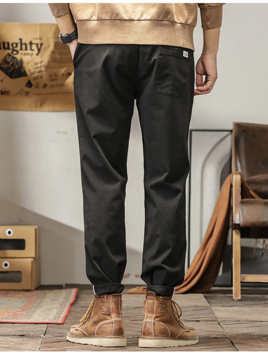 Men's black slim fit ankle pants with cuffed hem and back pocket detail.