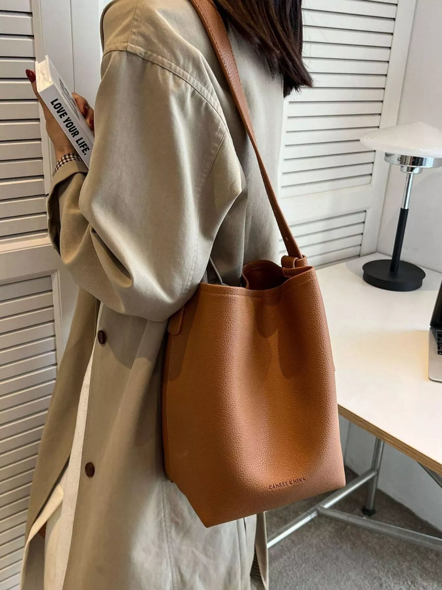 Brown pebbled PU leather shoulder bag with adjustable strap and subtle logo detail.