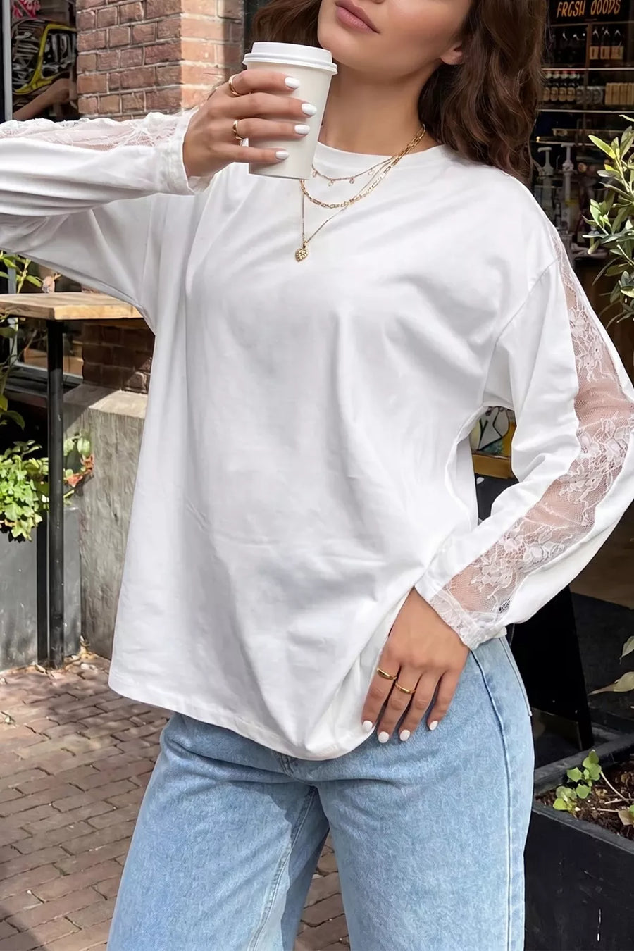 White long sleeve shirt with delicate lace paneling on the sleeves and crew neckline.