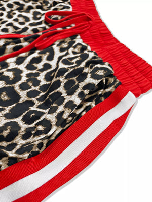 Leopard print lounge shorts with red drawstring and red and white striped trim.