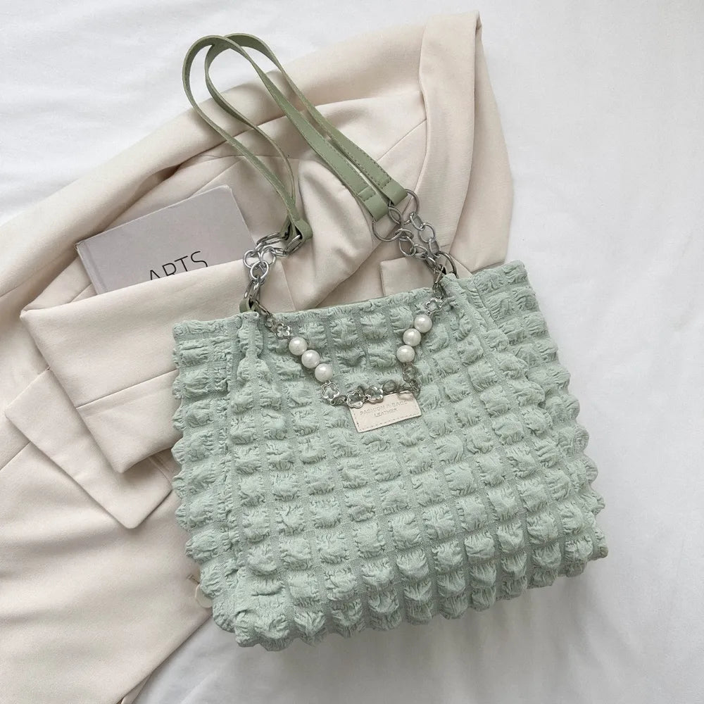 Light green textured grid pearl chain tote bag with chain straps.