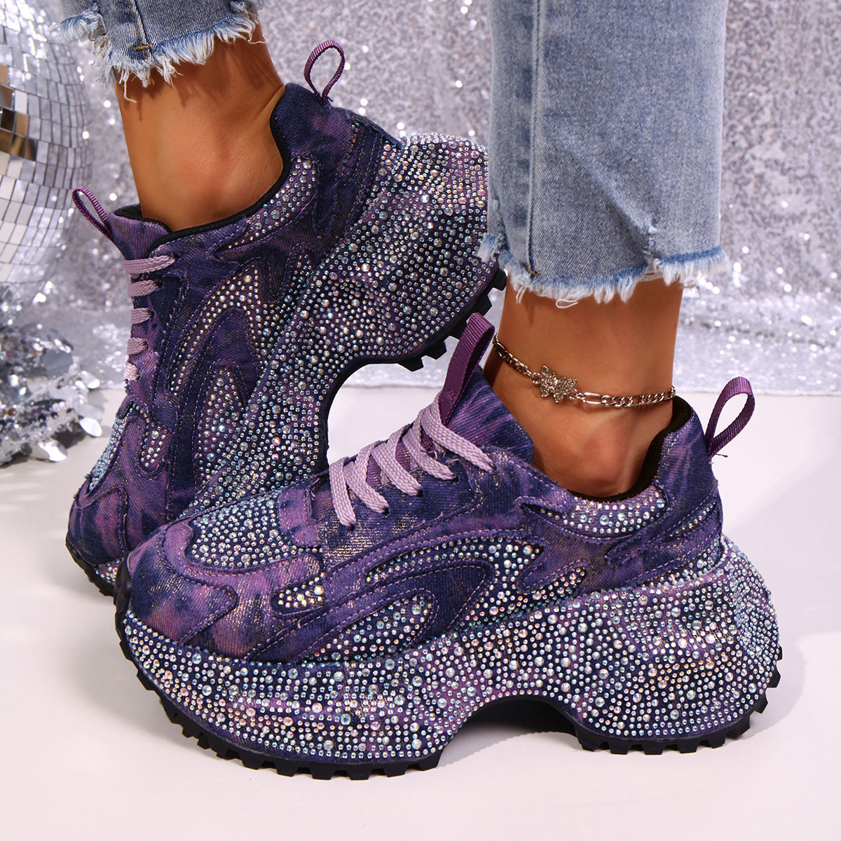 Purple rhinestone platform sneakers with chunky sole and tie-dye detail.